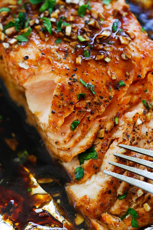 Easy and quick oven foil baked salmon with garlic sriracha glaze with a fork ready to serve.