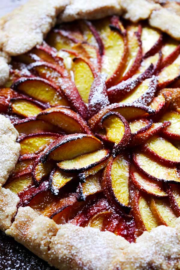 Close up of peach tart with fresh peaches.