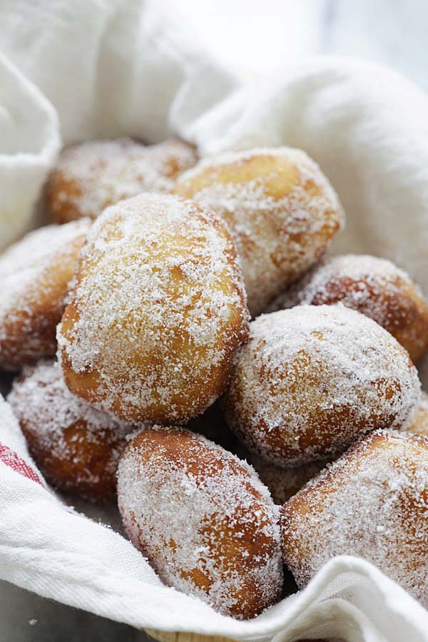 Fried golden-brown malasadas coated with granulated sugar.