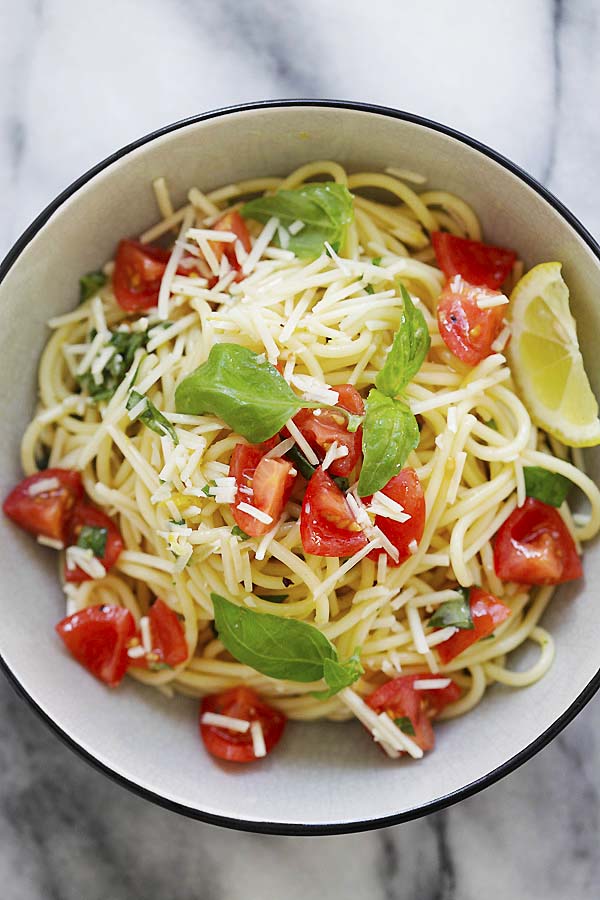 Saludable y deliciosa pasta para espaguetis con tomates, albahaca fresca, queso parmesano y salsa de limón.