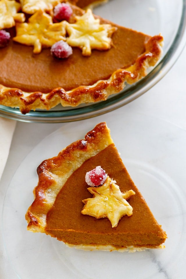 Close up photo of pumpkin pie with golden brown and pie crust with beautiful crimp edges.