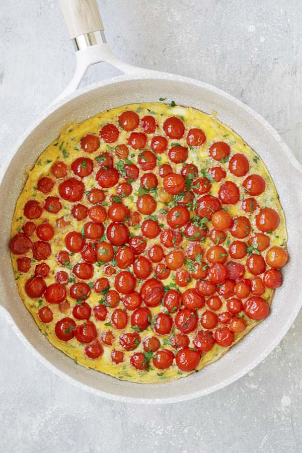 Easy and quick cherry tomato Italian frittata in a skillet.