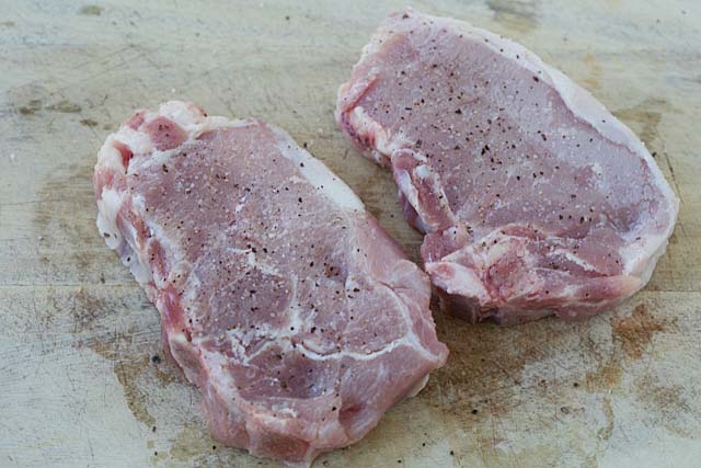 Bone-in pork chops seasoned with salt and ground black pepper. 