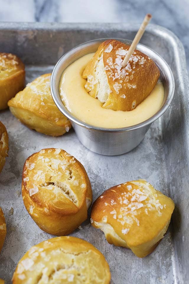 Dipping a homemade pretzel bite in cheddar cheese sauce.