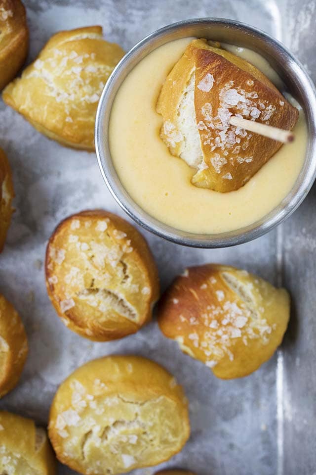 Dipping a homemade soft pretzel bite in cheddar cheese sauce.