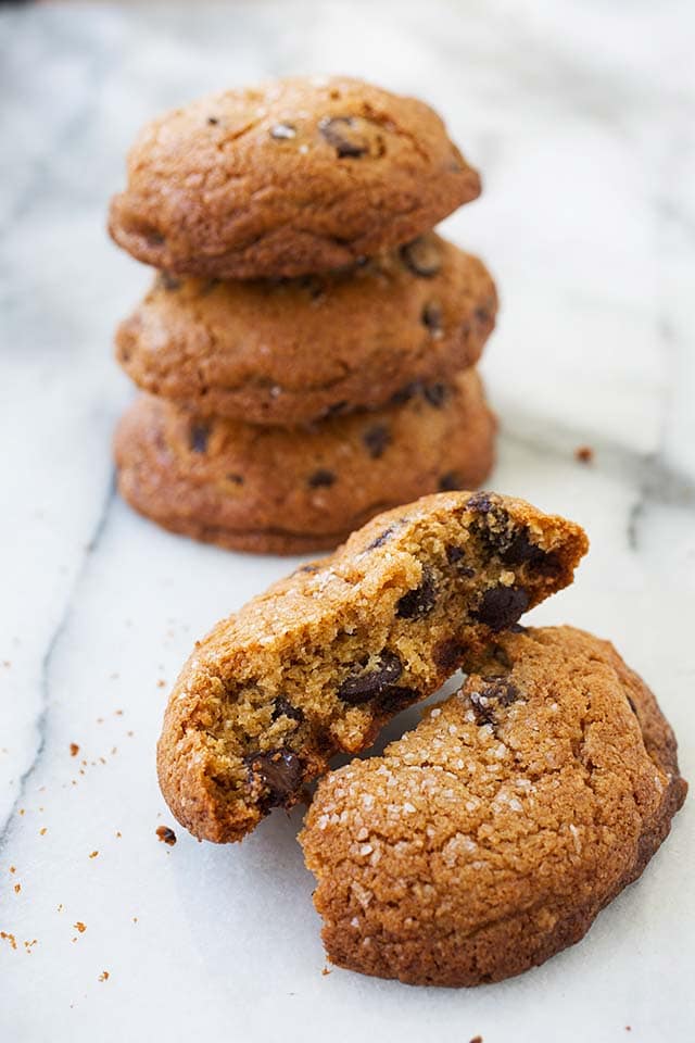 Close up picture of a big chocolate chip cookies broken up with chocolate chips inside.