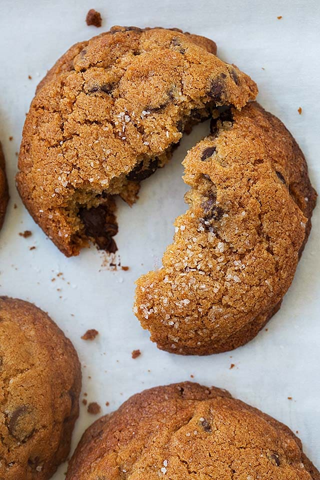 Salted chocolate chip cookies on a baking sheet lined with parchment paper.