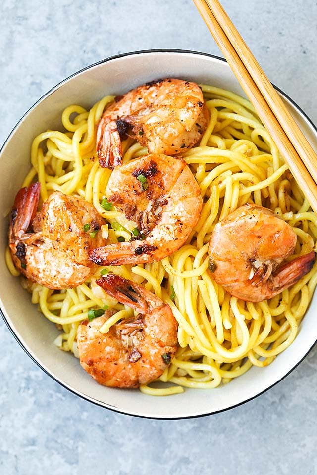 Top down photo of garlic noodles with shrimp in a bowl.
