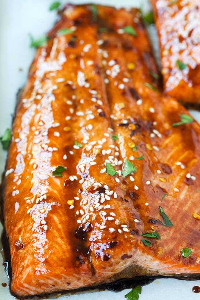 Soy glazed salmon garnished with white sesame and chopped parsley, ready to be eaten.