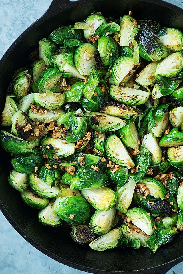 Top down picture of sauteed Brussels sprouts, with garlic on top.