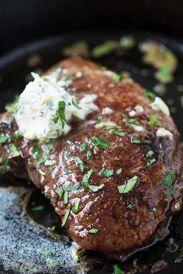 Close up photo of garlic butter steak in a skillet.