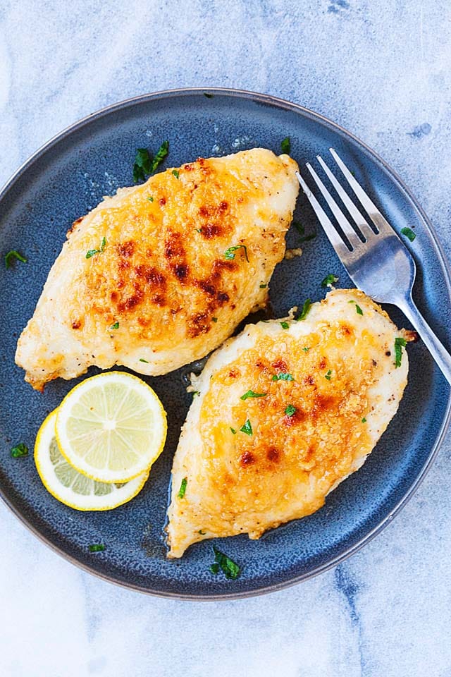 Two pieces of boneless baked chicken breasts on a plate.