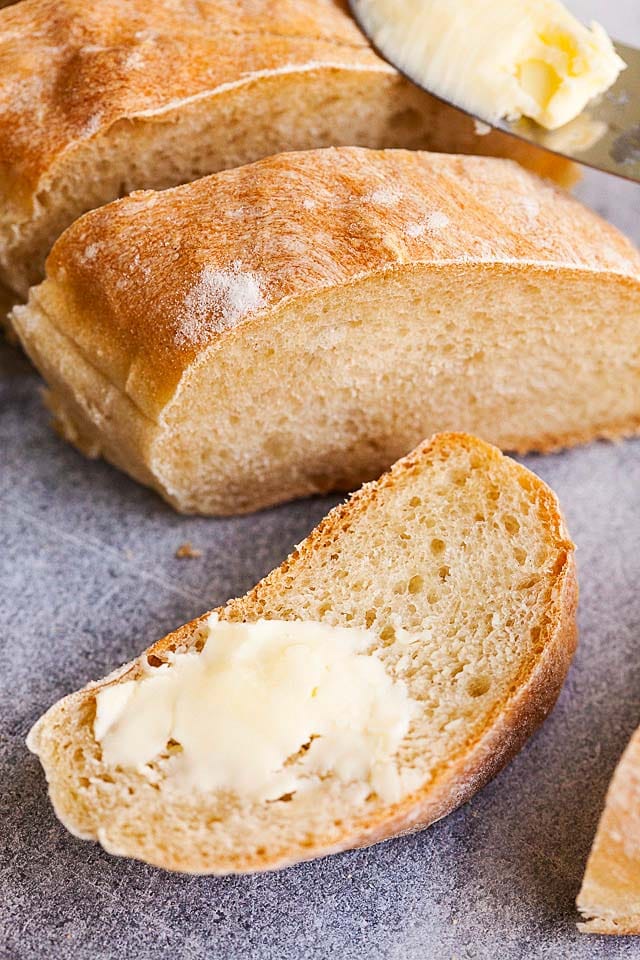 A piece of homemade baguette with butter.