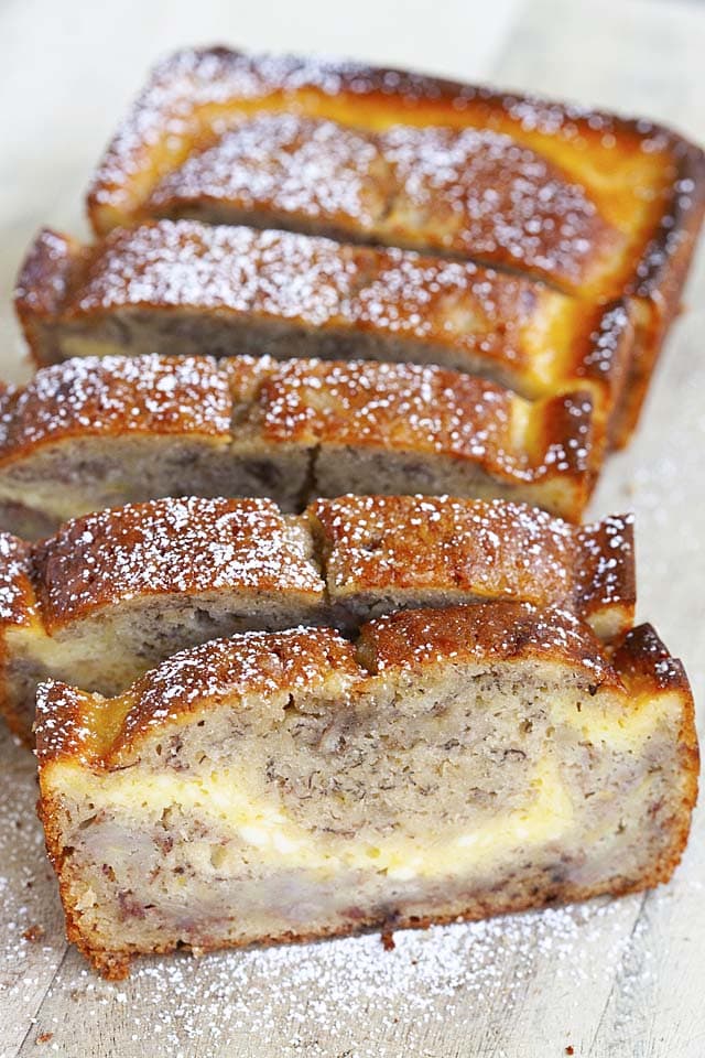 A loaf of cheesecake banana bread, sliced into pieces, ready to be eaten.