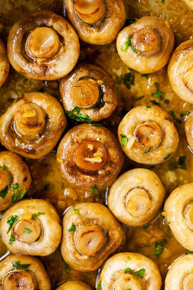 Top down shot of white mushrooms with garlic butter sauce.