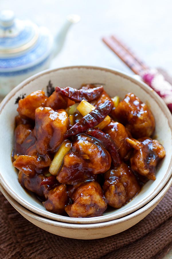 Spicy General Tso Chicken cooked with dried red chilies, in a serving bowl with chopsticks.