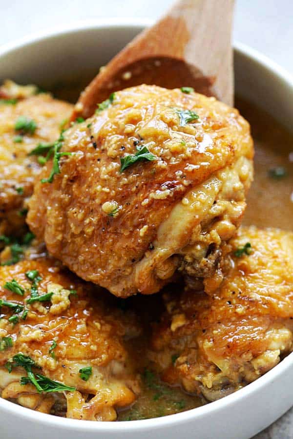 Honey Mustard Chicken thighs in a wooden spoon. The chicken thigh is fall-off-the-bones tender due to pressure cooking.