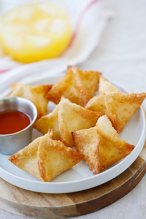 Crab rangoons on a white plate, ready to serve.