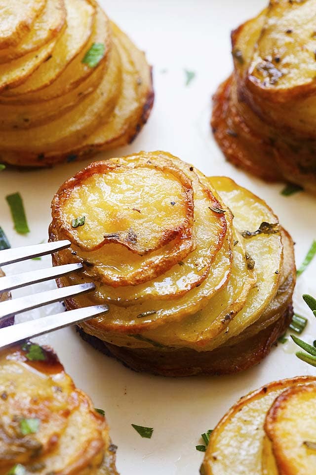 Potato stacks with a fork on a plate, ready to be served.