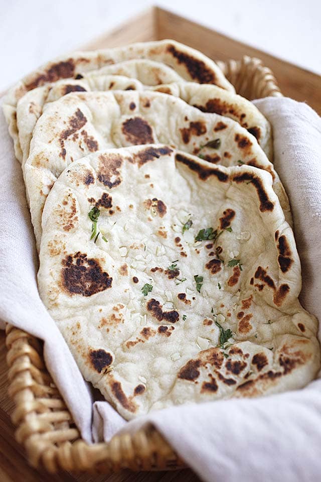 Garlic naan bread in a bread basket, ready to be eaten.