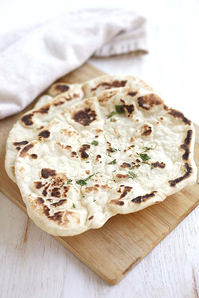 Garlic naan served on a wooden tray, ready to be served.