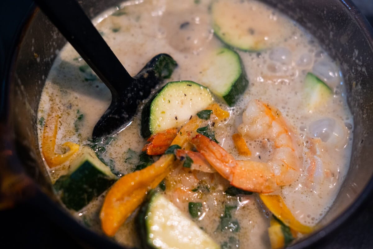 As soon as the shrimps are cooked, add the coconut milk, fish sauce, palm sugar, zucchinis and red bell peppers to the saucepan, and continue cooking for 1 minute. 