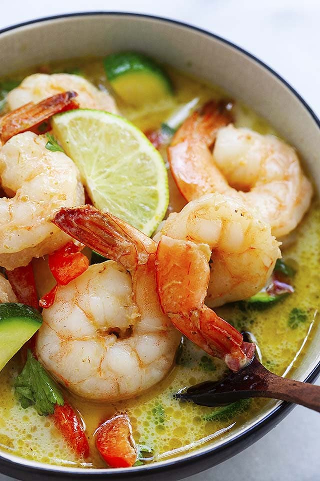 Thai shrimp curry with vegetables in a bowl and a wooden bowl.