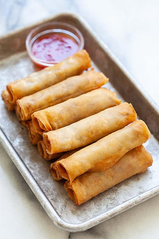 Lumpia or Filipino fried spring rolls on a plate with sweet and sour sauce ready to be served.