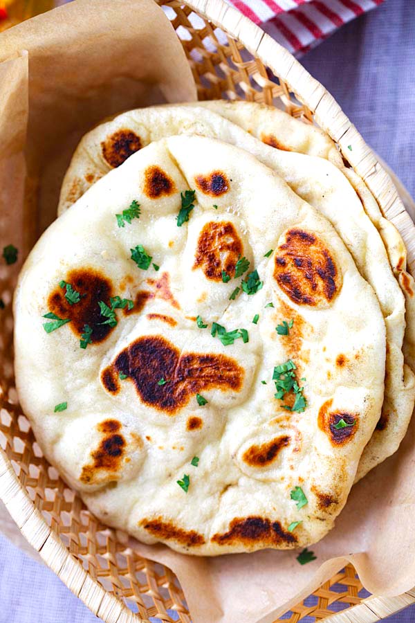 Soft and puffy naan bread in a bread basket. 