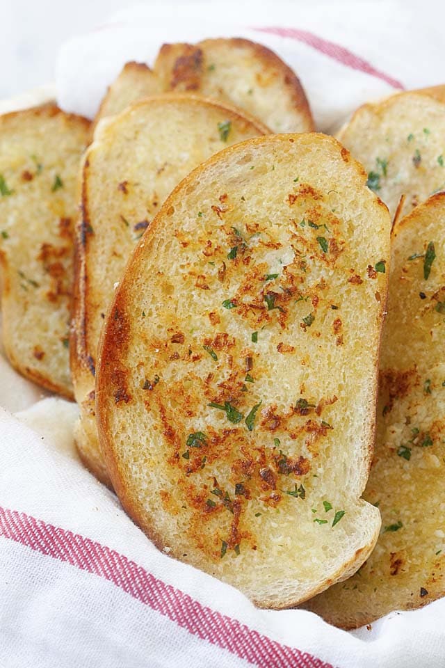  Mantenga caliente el pan de ajo de pan francés cubriéndolo con un paño de cocina en una cesta de pan.