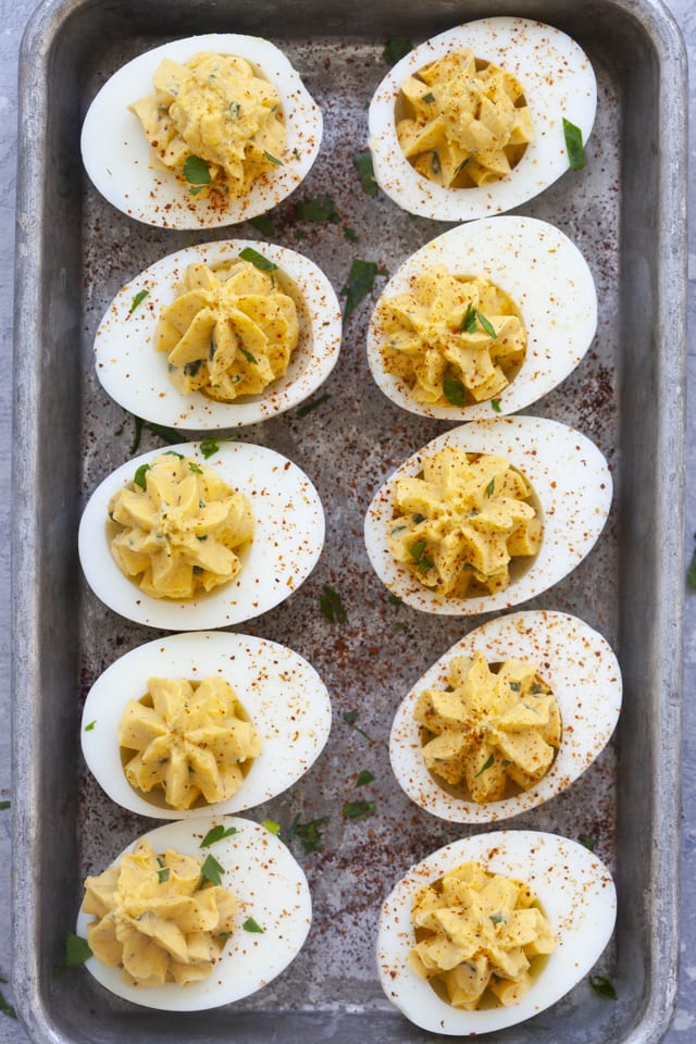 Ten deviled eggs in two rows, on a serving platter.