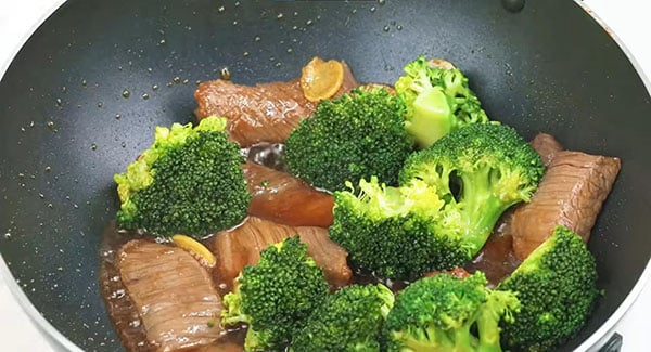 Beef and broccoli in a wok.