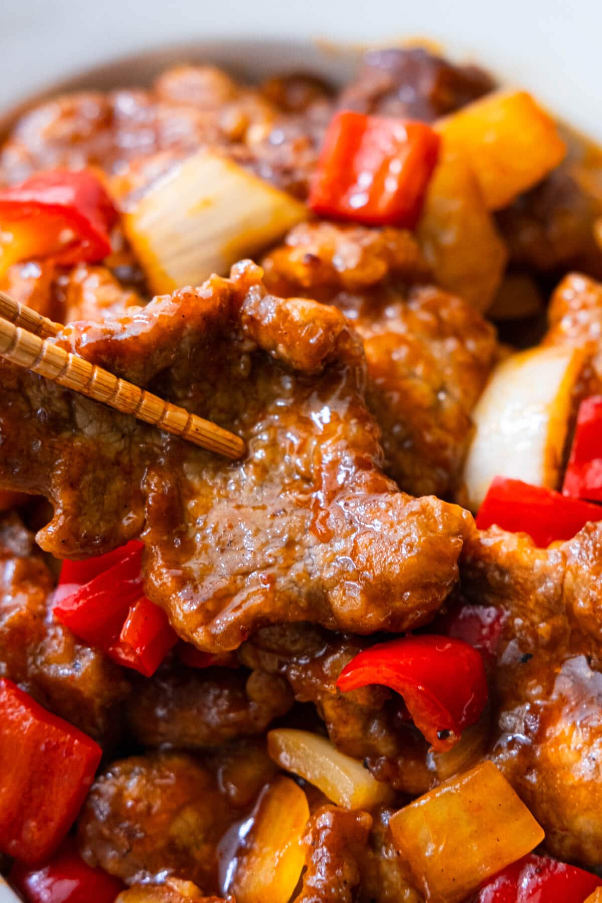 Spicy Beijing beef picked up with chopsticks.