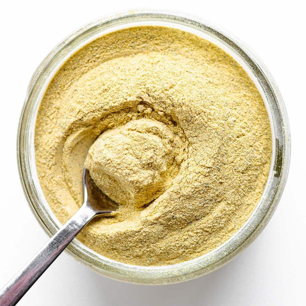 Chicken bouillon powder being scooped in a bowl.