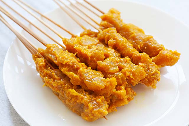 Raw, marinated chicken satay threaded on bamboo skewers.