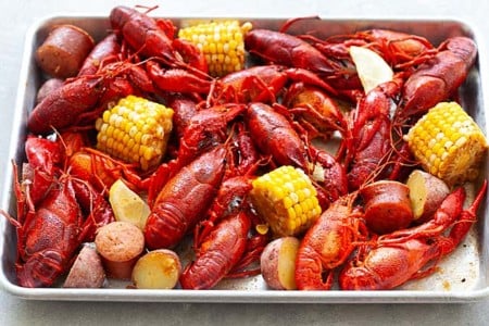 Fully cooked crawfish boil in a serving tray, ready to serve.