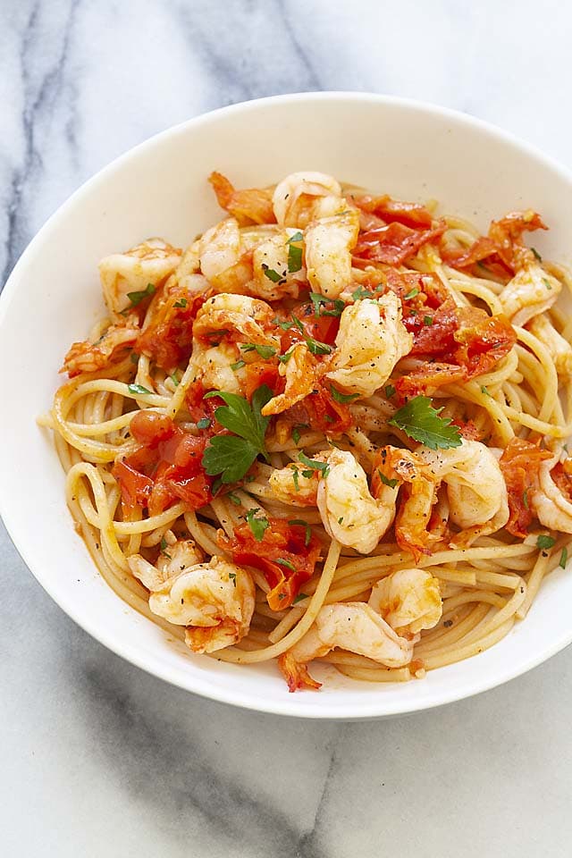 Easy shrimp and tomato pasta served on a plate with parsley. 