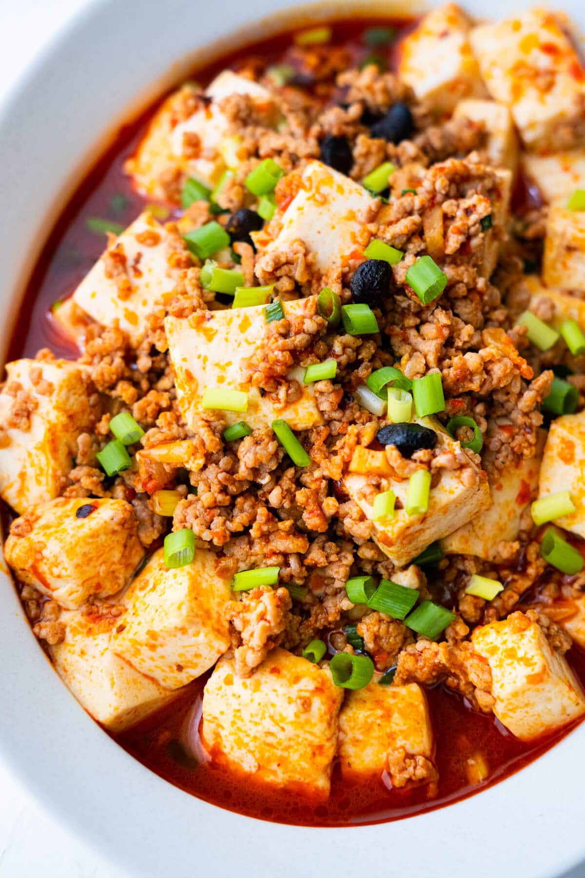 Mapo tofu with cut up tofu and minced meat in a bowl.