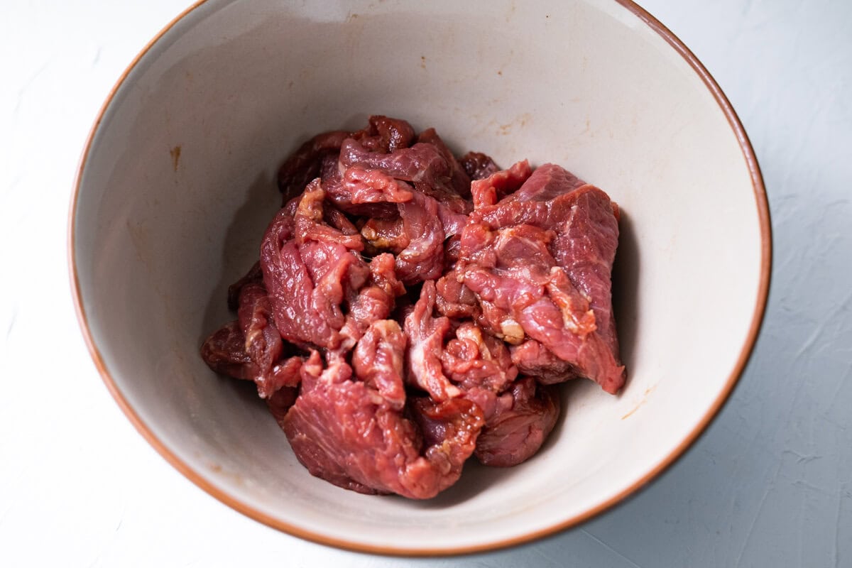 Marinade the beef slices in a bowl. 