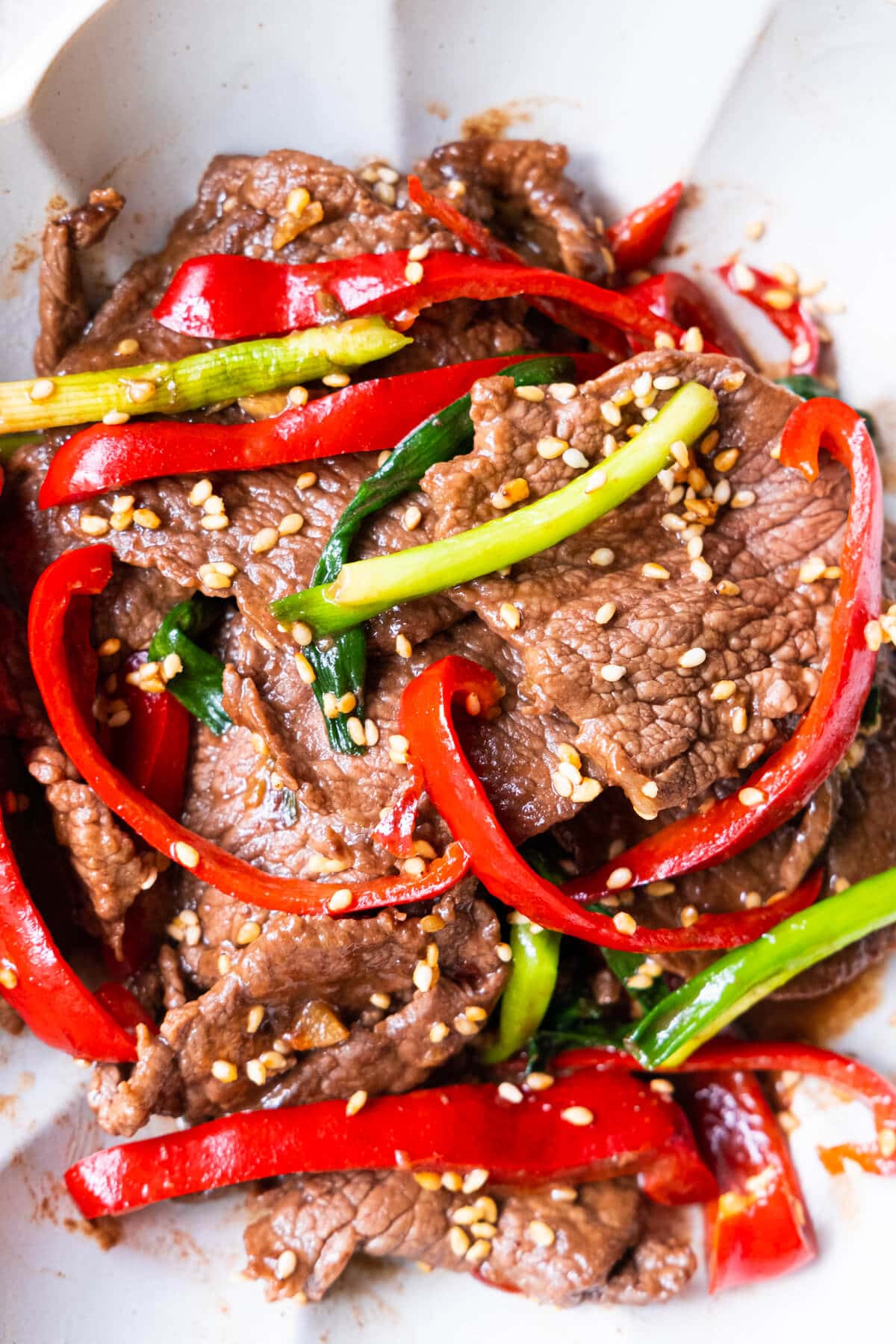 Asian stir-dry sesame Beef in brown sauce in a bowl.