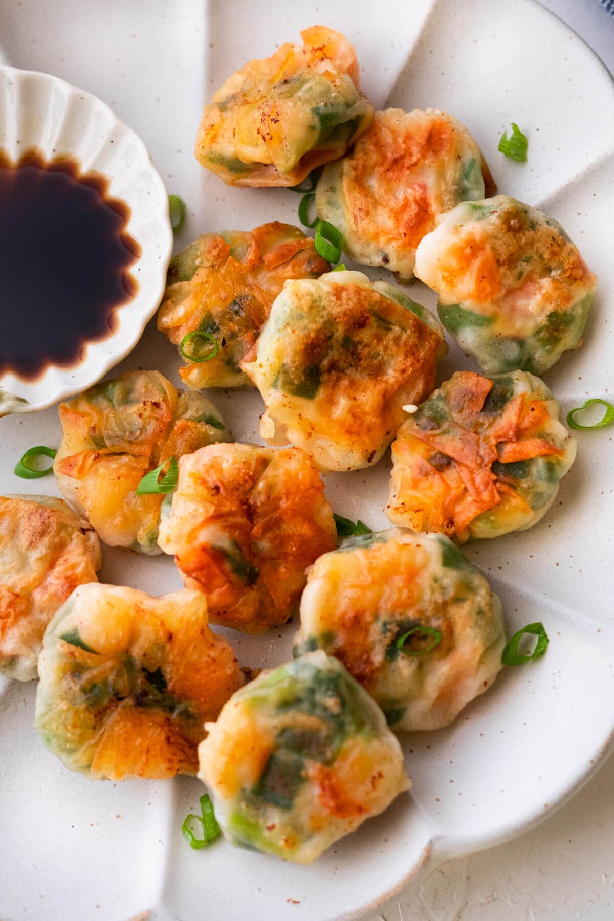 Easy pan fried shrimp and chive dumplings served on a plate with dipping sauce. 