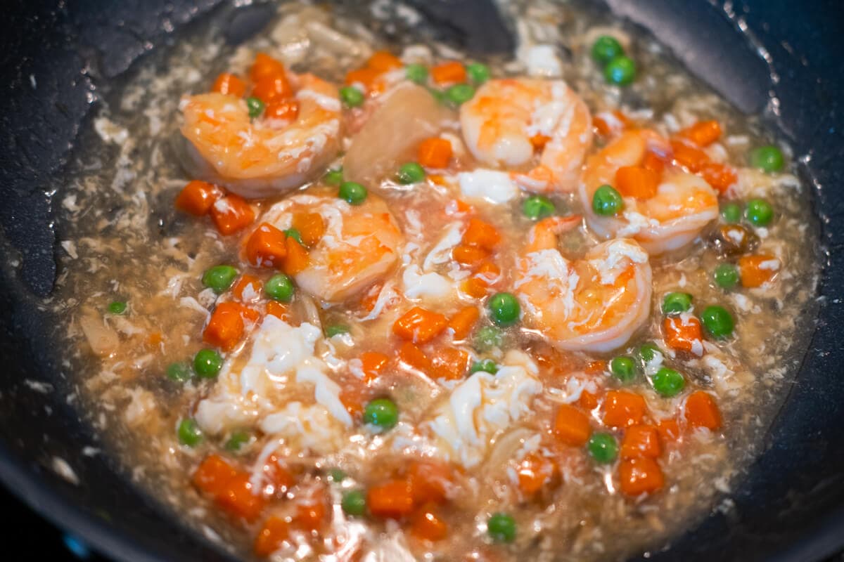 Adding egg white mixture to the shrimp. 