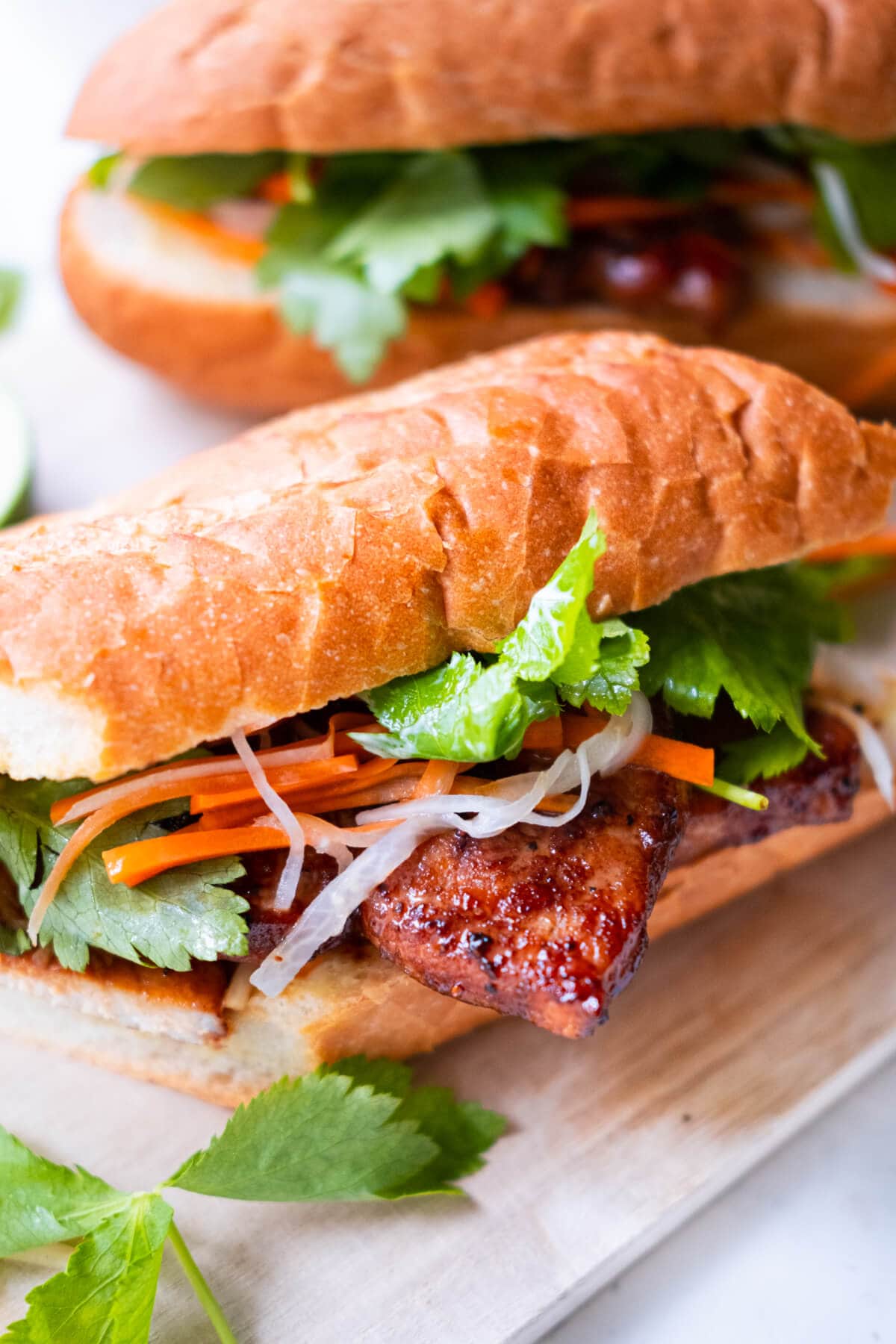Traditional banh mi recipe with grilled pork and pickled vegetables in between a French baguette. 
