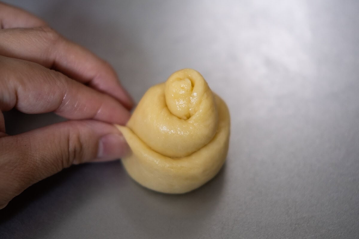 Brioche dough is shaped into a bun. 