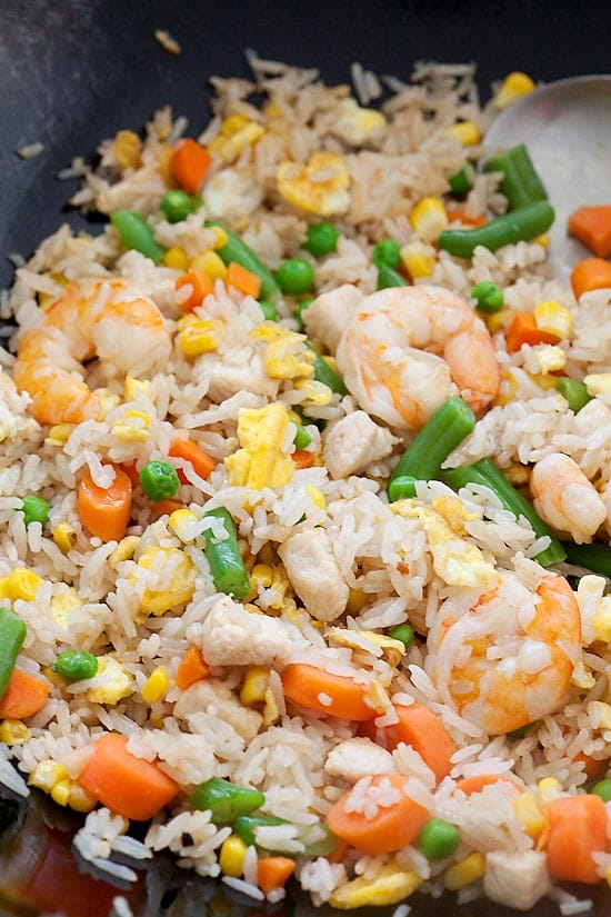 Fried rice restaurant style is the best fried rice in the world, with egg, chicken, shrimp and mixed vegetables in a skillet.