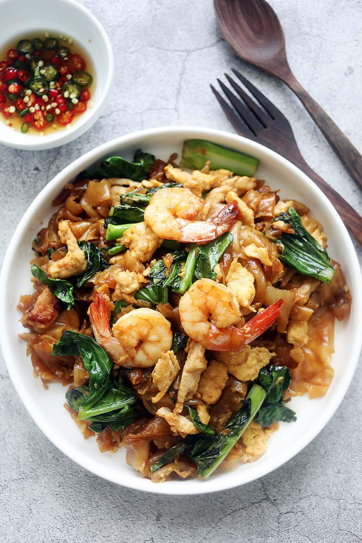 Pad See Ew (pad see yew or phat si-io) with shrimp, chicken and vegetables on a plate.