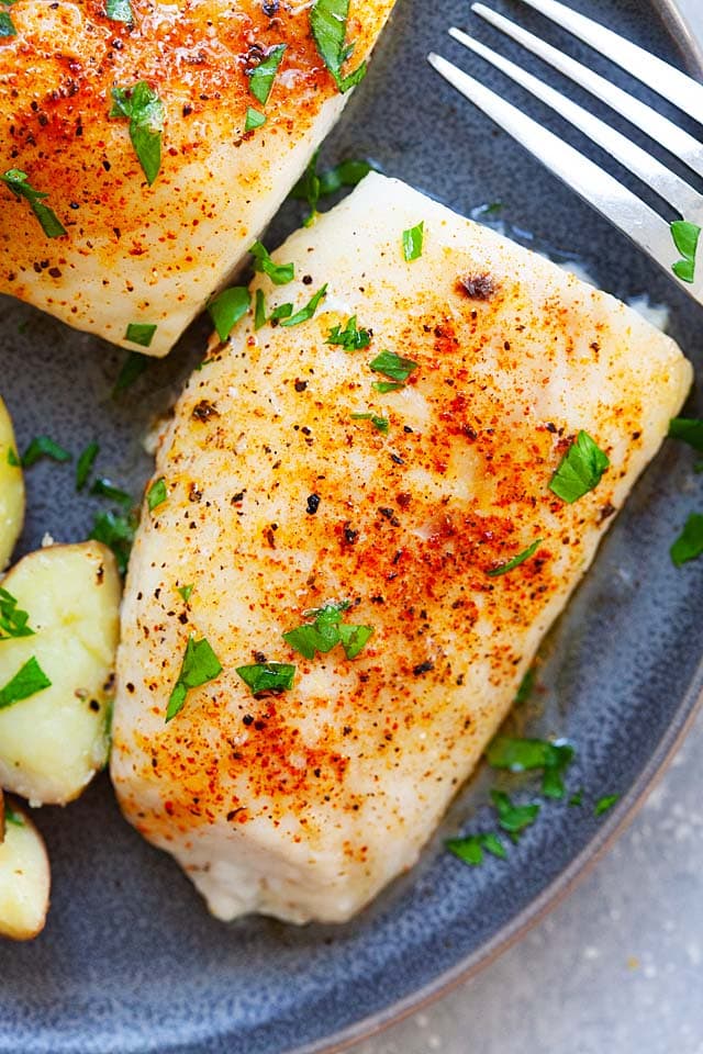 Juicy and moist baked cod fish fillets, topped with chopped parsley leaves. 