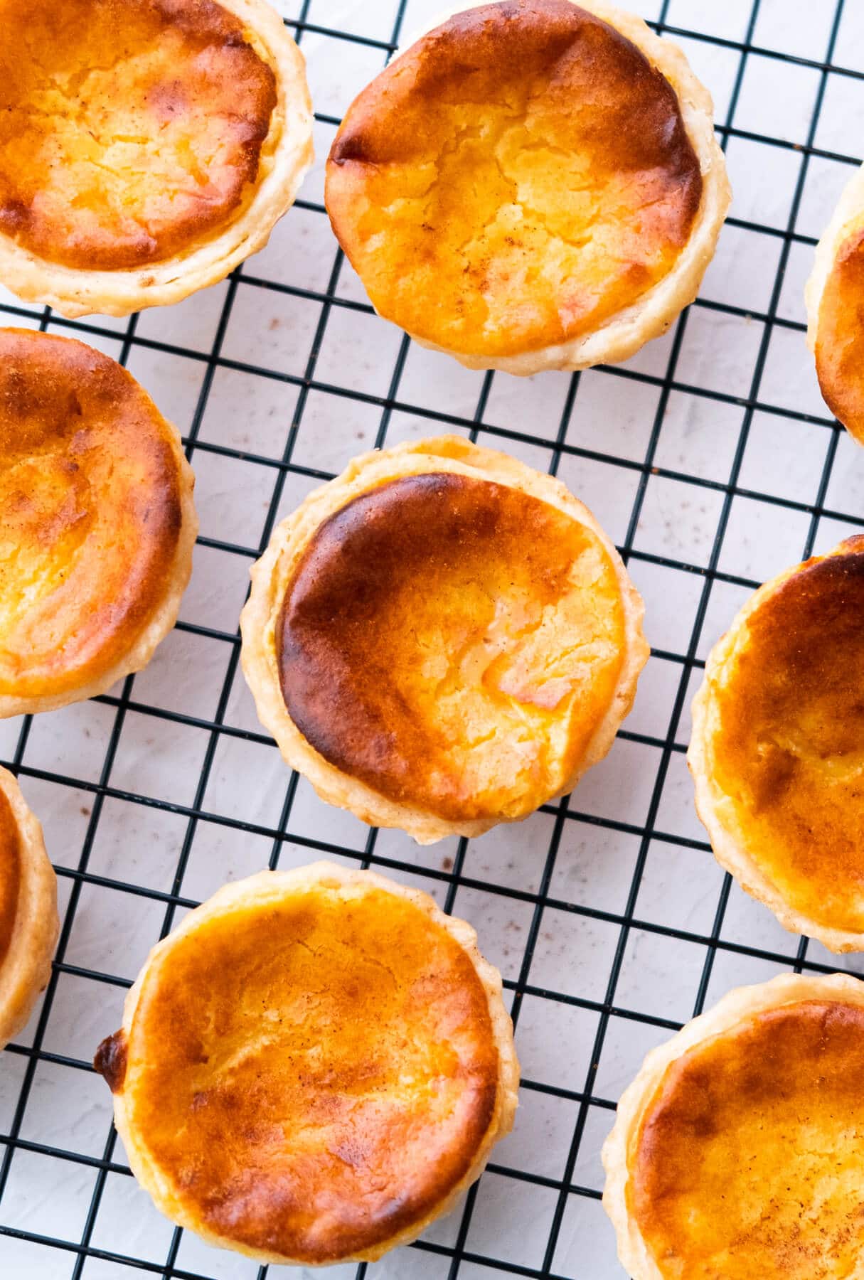 Portuguese egg tarts on a wire rack. 