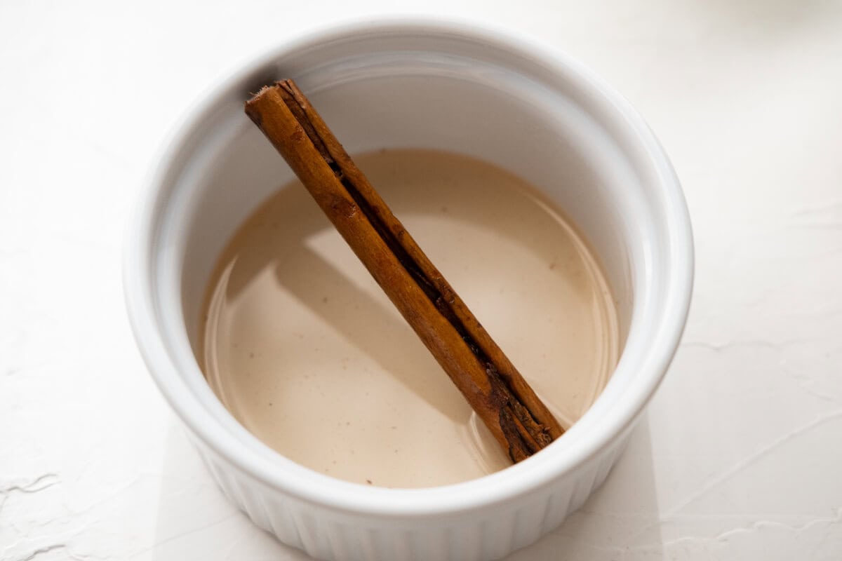 Syrup and cinnamon stick in a bowl. 