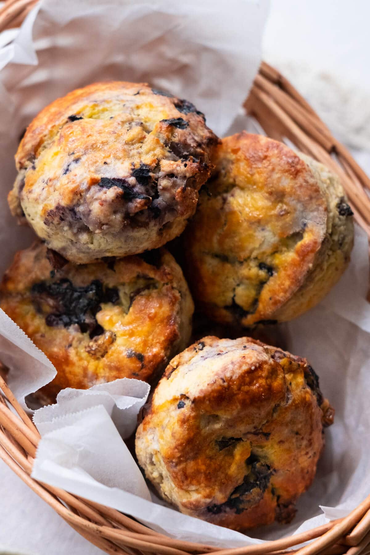 Delicious afternoon tea scones made with blueberries and placed in a basket.